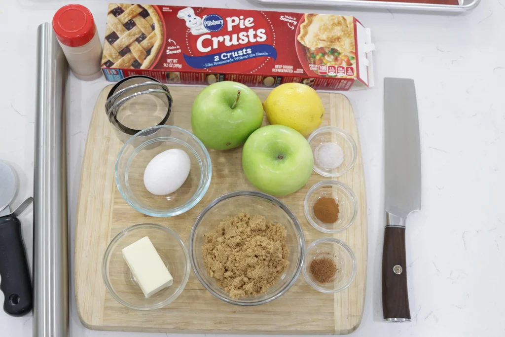 Several ingredients on a wooden cutting board for making apple pie. Several ingredients on a wooden cutting board for making apple pie.