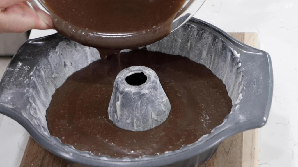 Chocolate oreo cake batter poured into a buttered and floured fluted bundt cake pan. Chocolate oreo cake batter poured into a buttered and floured fluted bundt cake pan.