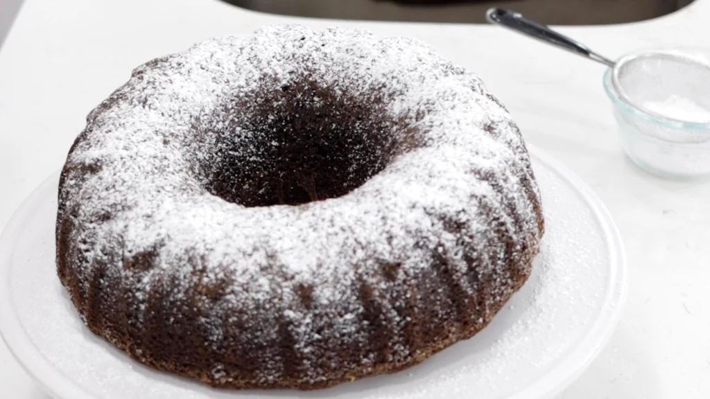 Finished Oreo bundt cake on a white cake pedestal. Finished Oreo bundt cake on a white cake pedestal.