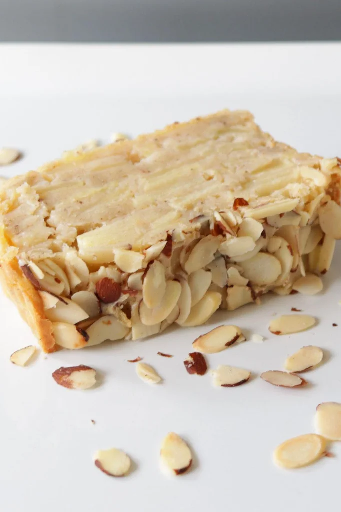 Slice of invisible apple cake with almonds.