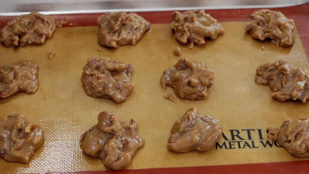 Unset pecan pralines on a sheet pan lined with parchment paper. Unset pecan pralines on a sheet pan lined with parchment paper.