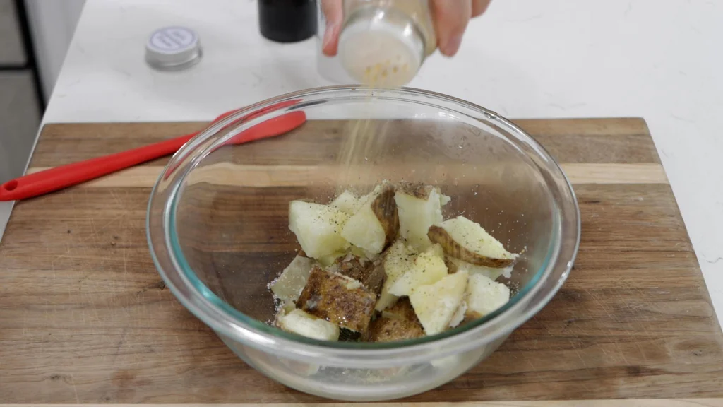Bowl of boiled potato chunks with seasoning. Bowl of boiled potato chunks with seasoning.