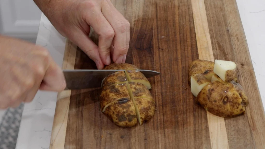 Hand slicing potatoes with a knife. Hand slicing potatoes with a knife.