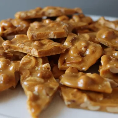 Pile of microwave peanut brittle on a white plate.