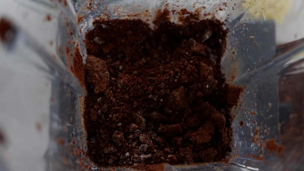 Cocoa nibs and other ingredients in a blender. Cocoa nibs and other ingredients in a blender.