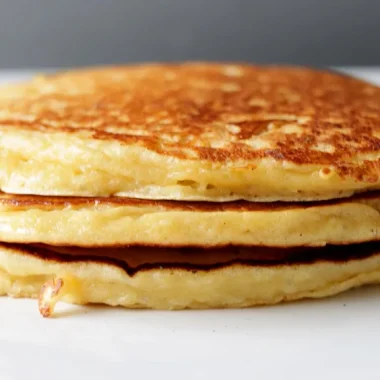 Stack of cottage cheese pancakes on a white plate.