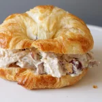 A look at a croissant chicken salad sandwich on a white plate