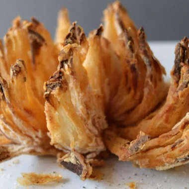 Air fryer blooming onion on a white plate.
