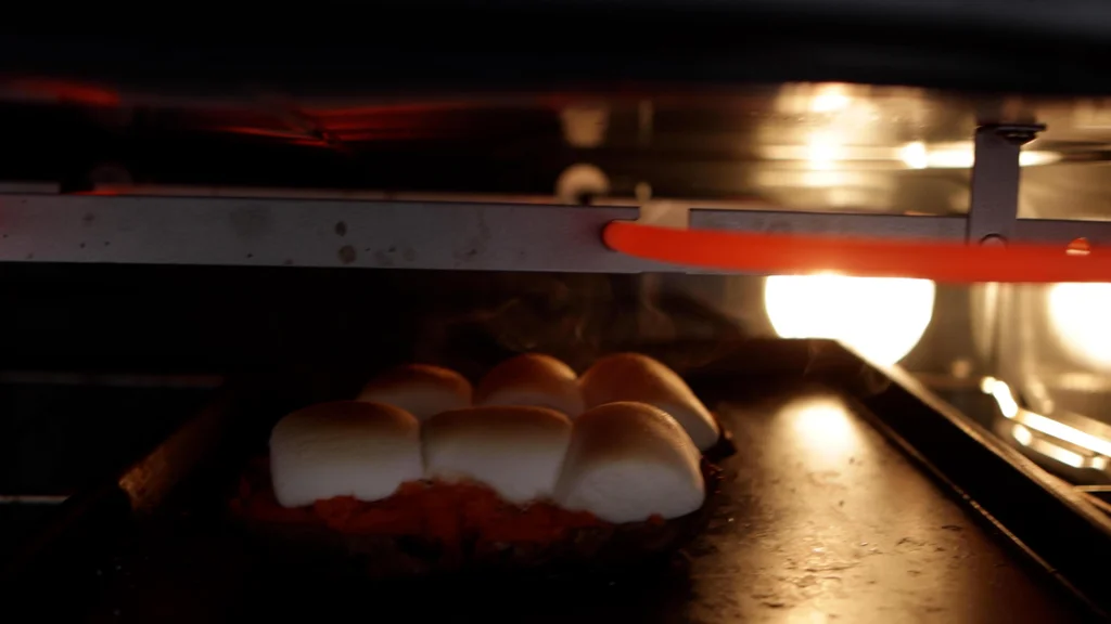 Sweet potatoes with marshmallows on top under the broiler. Sweet potatoes with marshmallows on top under the broiler.