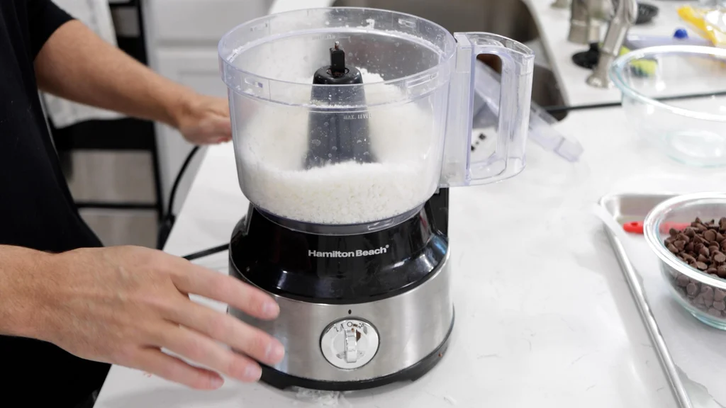 Coconut flakes in a food processor. Coconut flakes in a food processor.