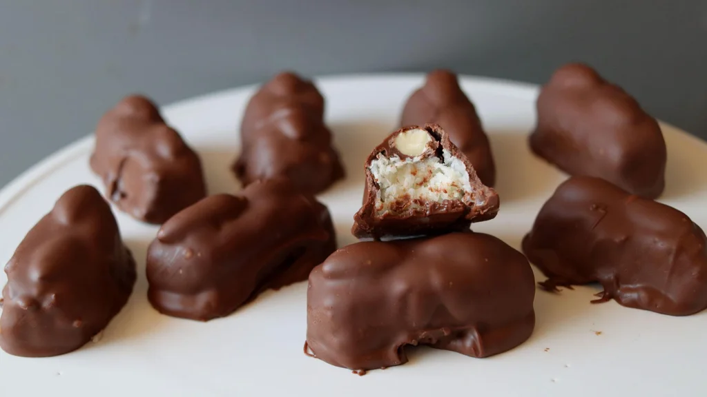 Several copycat homemade almond joys sitting on a white platter.